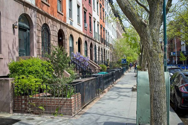 New York, NY, USA - July 8, 2021: Sidewalk and adjoining brownstone residences in the west Chelsea neighborhood of Manhattan