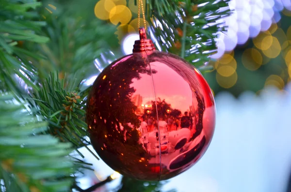 Fondo de Navidad con un adorno rojo, caja de regalo de oro, bayas y abeto en la nieve — Foto de Stock