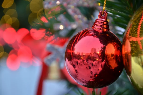 Fond de Noël avec un ornement rouge, boîte cadeau doré, baies et sapin dans la neige — Photo