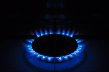 Beyaz, modern mutfak sobasında gaz ocağı. Yanan propan gazlı mutfak ocağı..