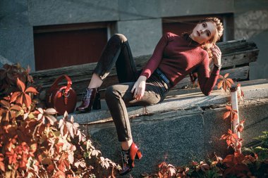 Siyah kotlu ve koyu kırmızı çantalı güzel bir kız. Tarz sahibi bir kızın portresi. Yüz çekimi, sokak tarzı ve moda. Profesyonel model..