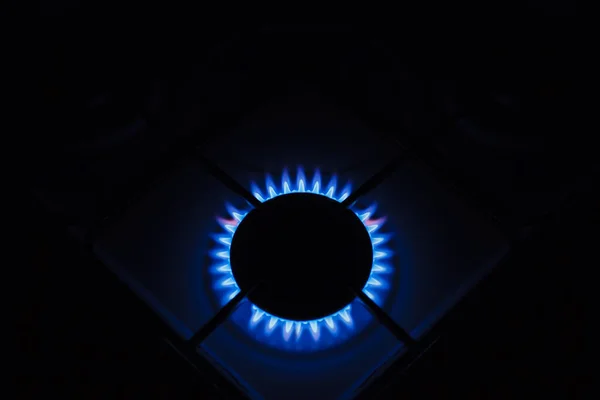 Gas burner on white modern kitchen stove. Kitchen gas cooker with burning fire propane gas.