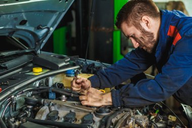 Araba servisi ve bakım yapan tanınmayan tamircinin ellerini kapat. Araba motorunda çalışan tamirci. Otomobil tamiri, servis merkezi. Araba servis merkezinde ingiliz anahtarı çalışan ve araba tamir eden bir tamirci..