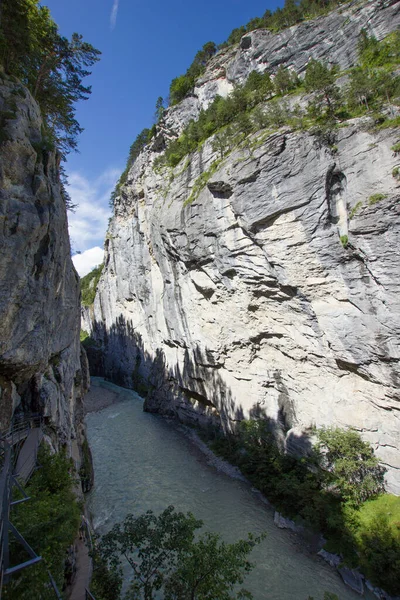川の印象的な渓谷は美しいスイスのアルプスにあります ストック画像