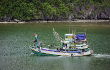 Denizde yüzen balıkçı tekneleri. Teknedeki balıkçılar. Dağda yüzen balıkçı teknesi.