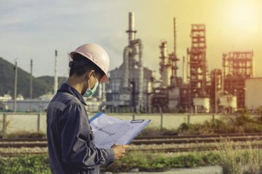 Erkek işçiler endüstriyel inşaat sahası petrol ve gaz rafinerisinde inceleme ve kayıt işlemleri yapıyorlar..