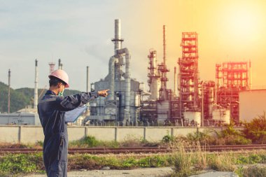 Erkek işçiler endüstriyel inşaat sahası petrol ve gaz rafinerisinde inceleme ve kayıt işlemleri yapıyorlar..