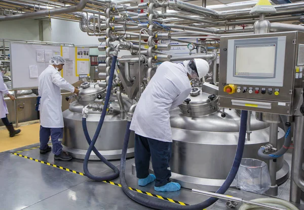 Male two work the process of cream cosmetic fermentation at the manufacturing with stainless tank on the background