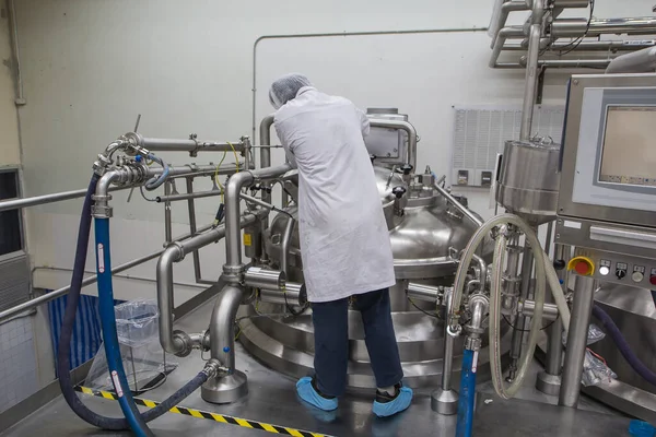 Male  work the process of cream cosmetic fermentation at the manufacturing with stainless tank on the background