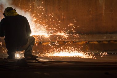 Koruyucu giysiler giyen ve kapalı alanlarda depolama kaplaması yangını ve dumanı tamir eden erkek işçiler.