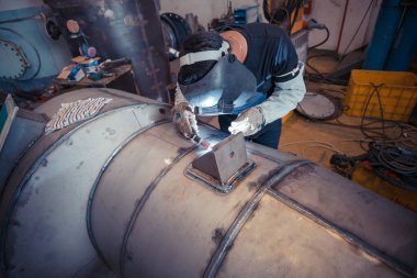 Tamir borusundan koruyucu giysiler giyen erkek işçi paslanmaz argon endüstriyel kaynaklama