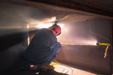 Koruyucu giysiler giyen ve yüzen duba sanayi inşaat yağı ve gaz veya kapalı alanlarda kaynakçılık yapan erkek işçiler..