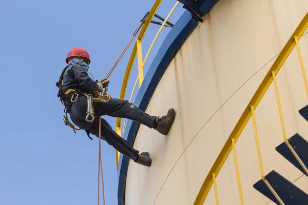 Male worker rope access  inspection of  storage tank oil industry.