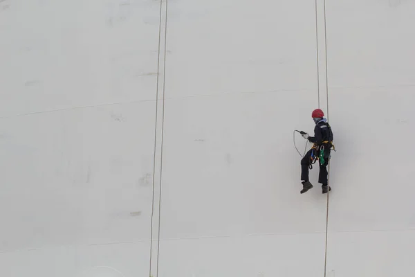 Male worker rope access  inspection of thickness storage tank industry.