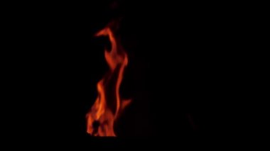 Gerçek ateş alevleri ve kıvılcımlar siyah arka planda izole edilmiş ağır çekimde. Çimlerden çıkan şenlik ateşi. Efekt yaratmak için ateş.
