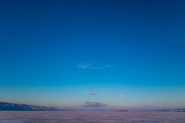 シベリアロシアのバイカル湖の氷の上で冬の月を見下ろす幻想的な夕日 自然の風景 自然の雄大さ スペースのコピー — ストック写真