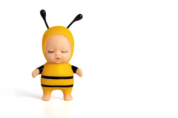 Cute little doll in a bee costume with closed eyes. Stands on a white Cisolated background. Soft focus. Copy space. — Stock Photo, Image