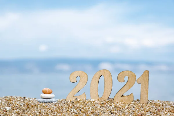 Yaratıcı Noel kartı. Deniz kıyısındaki sahilde 2021 numaralı yeni yıl. Turizm, dinlenme ve seyahat konsepti. Boşluğu kopyala.