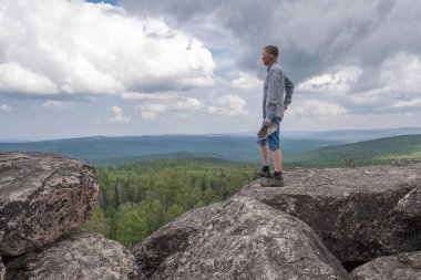 Dağın tepesindeki orta yaşlı bir adam tepe vadisinin çarpıcı manzarasının tadını çıkarıyor. Özgürlük ve hedefe ulaşmak.