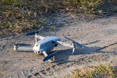 İHA yerde duruyor ve kalkmaya hazır. Gri İHA 'nın yakın çekimi. Kolye kamerası ve uzaktan kumandalı UAV ile uçuyor. Hava fotoğrafçılığı ve video kaydı.