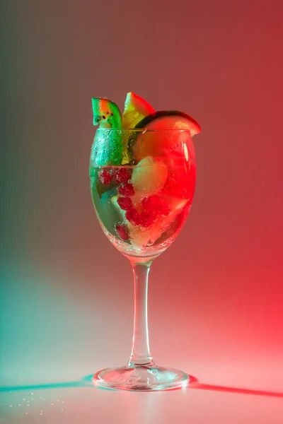유리잔에 과일과 색깔의 조명을 칵테일 마시는 나이트클럽 — 스톡 사진