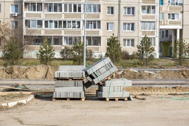 Yeni beton kaldırımlar, tahta paletler, yol çalışmaları. İnşaat, şehrin yerleşim bölgesinde yol onarımı