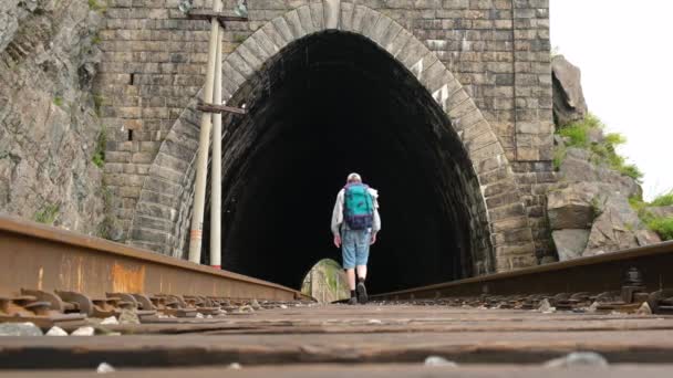 Turista Masculino Con Mochila Camina Largo Los Rieles Del Ferrocarril — Vídeo de stock