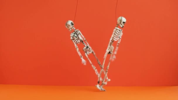 Two Suspended Skeletons Dance Orange Background Preparing Halloween Party Scary — Stock Video