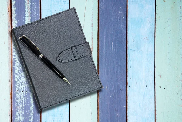 Caderno de couro preto com caneta em madeira Vintage — Fotografia de Stock