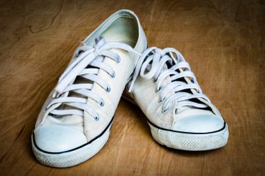 Ahşap arka plan üzerinde beyaz spor ayakkabı