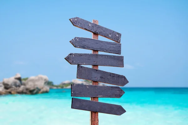 Wood signs on the beach. Sea and blue sky background blur