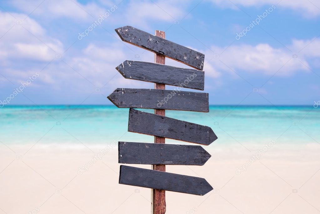 Wood signs on the beach. Sea and blue sky background blur