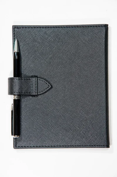 Caderno de couro preto e caneta isolada no fundo branco — Fotografia de Stock