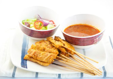 Izgara domuz eti satay, fıstık sosu ve beyaz zemin üzerine sirke