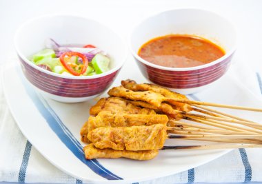 Izgara domuz eti satay, fıstık sosu ve beyaz zemin üzerine sirke