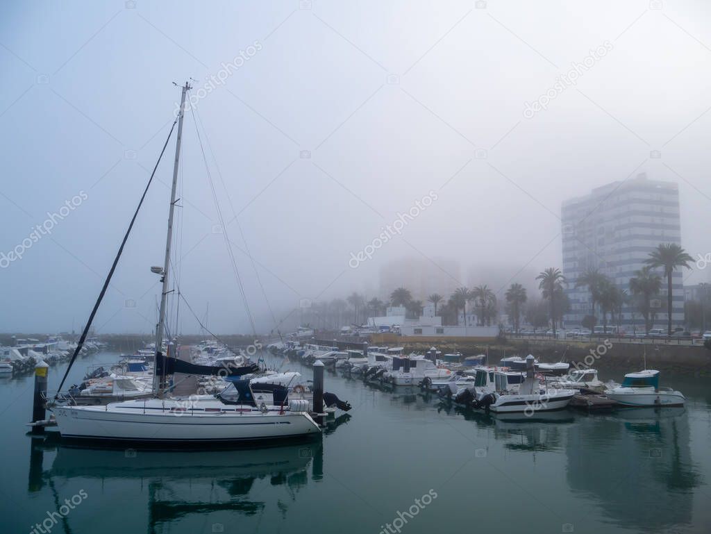 Boats in the fog in the bay of Cadiz capital, Andalusia. Spain. Europe.