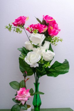 pembe çiçekli ve yeşil yapraklı vazo.