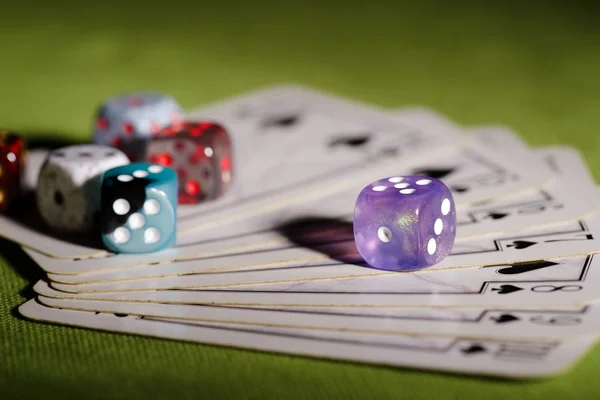 Purple dice on used playing cards — Stock Photo, Image