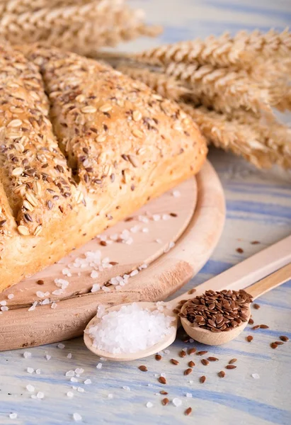 Twee lepels met lijnzaad en zout naast brood — Stockfoto