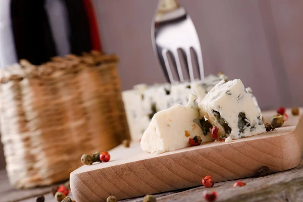 Paar stukjes van de blauwe kaas op houten bord — Stockfoto