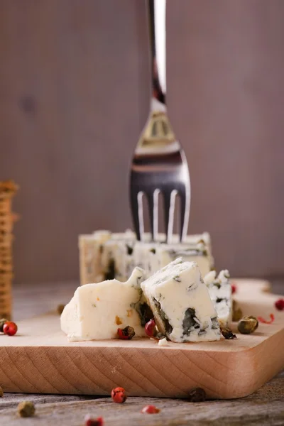 Paar stukjes blauwe kaas met de peper zaden rond — Stockfoto