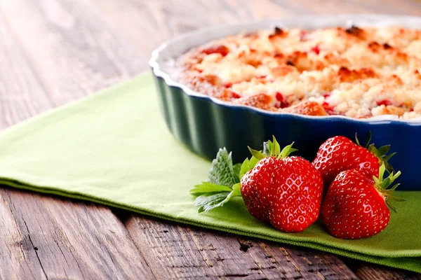 Tres fresas rojas frescas frente a pastel de frutas en toalla verde — Foto de Stock