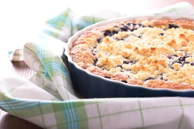 Mavi pişirme çanağı kareli kumaş üzerine taze yaban mersini turtası