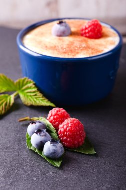 Kremsi tatlı ile kayrak taş üzerinde yaban mersini ve ahududu