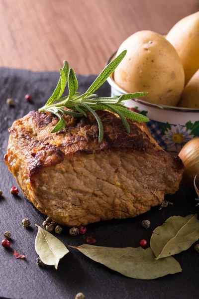 Trozo de carne de cerdo al horno sobre piedra pizarra —  Fotos de Stock