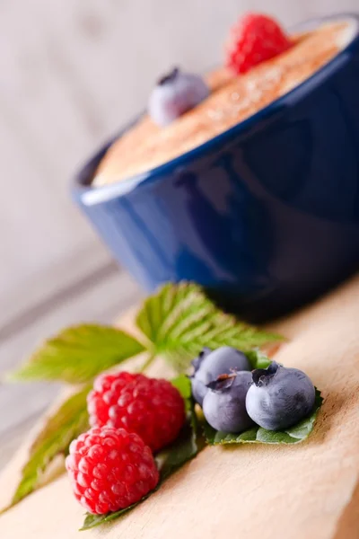 Fresh summer berries in front of dessert in blue bowl — Stock Photo, Image