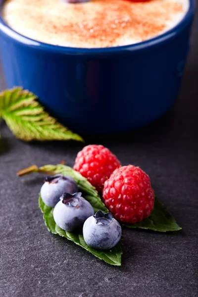 Red and blue berries on slate stone — Stock Photo, Image
