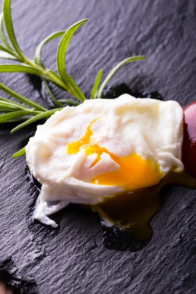 Single poached egg on slate stone with herb — Stock Photo, Image