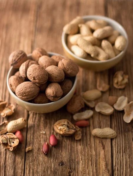 Two bowls with peanuts and walnuts — Stock Photo, Image