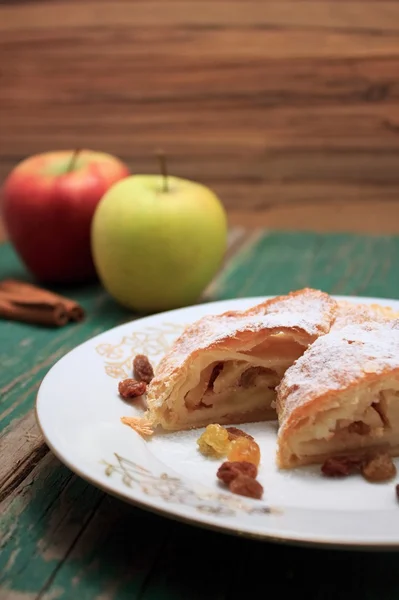 Apple pie strudel on white plate with gold ornament